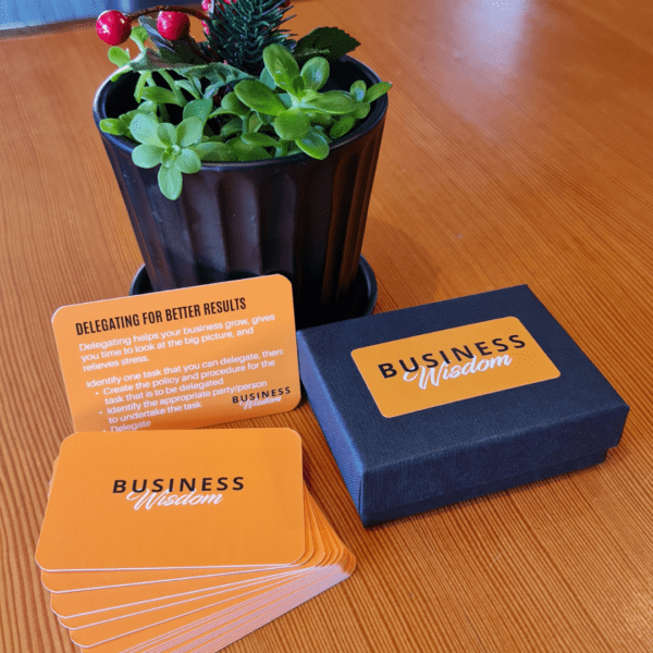 Business Wisdom Deck by Clive Enever accompanying a potted plant on a table.