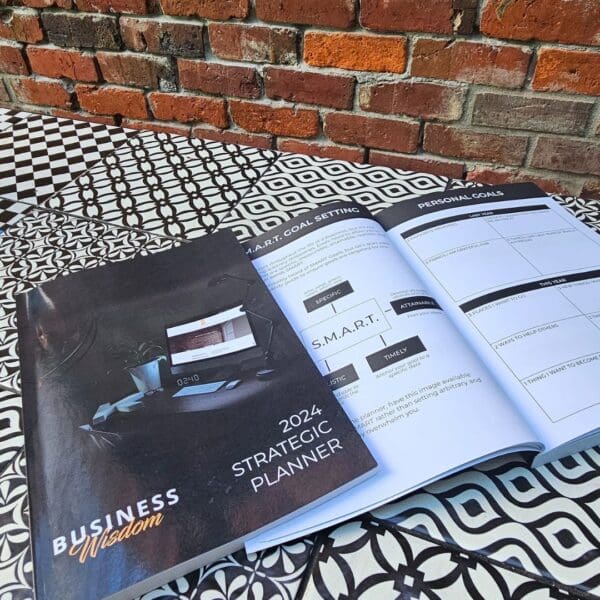 The Strategic Planner book on a table next to a brick wall.