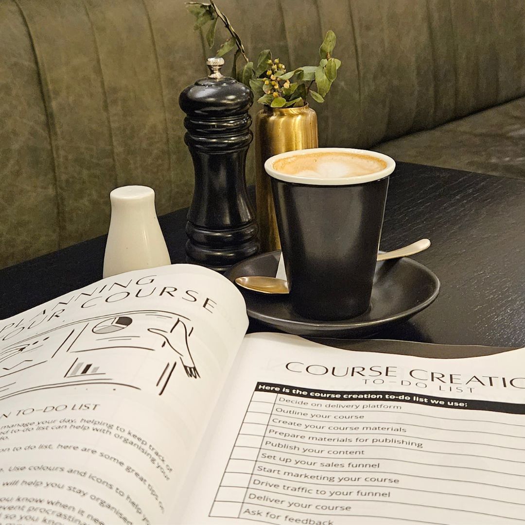 The Course Creators Circle: Course Creation Guidebook - Create That Course with a cup of coffee on it sits on a table.