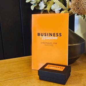 A box of Business Wisdom: Strategies for Success sitting on a table next to a vase.