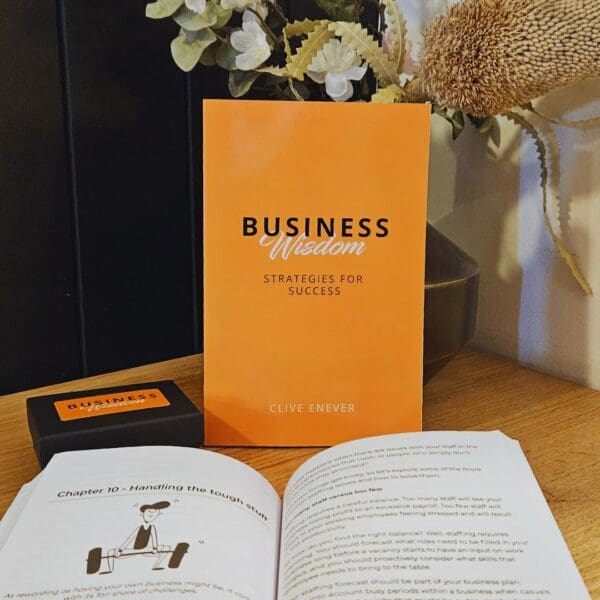 A book on a table next to a vase of flowers, showcasing Business Wisdom: Strategies for Success.