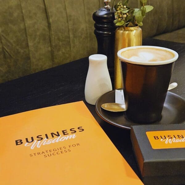 A cup of coffee sits on a table next to a Business Wisdom: Strategies for Success card showcasing strategies for success.